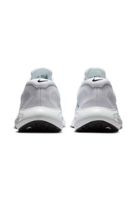 Witte sportschoenen met subtiele textuurdetails, een zwart Nike-logo en blauwe accenten op de hiel. Dikke, gevoerde zolen.
