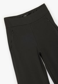Svarta sportleggings gjorda av elastiskt tyg, med hög midja och två dragkedjefickor på framsidan.
