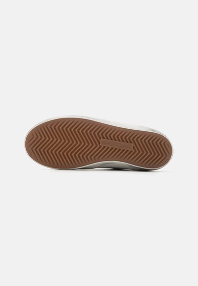 Podeszwa Sneakersów z wzorem w jodełkę. Beżowa gumowa podeszwa. Górna część w białym i szarym kolorze, o gładkiej fakturze, minimalistycznym designie i bez widocznego logo.