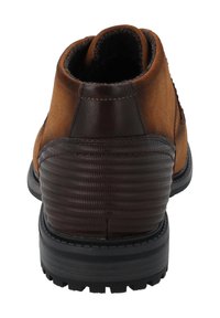 Stivaletto in suede e pelle marrone con tacco testurizzato marrone e suola in gomma nera. Presenta una punta arrotondata e cuciture rinforzate.