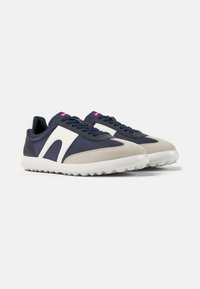 Navy and cream sneakers made of textile and suede, featuring a rounded toe, lace-up front, and a textured rubber sole.