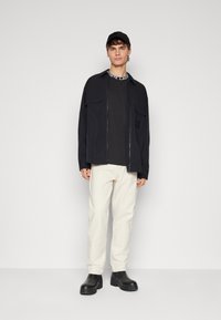 Lacoste CORE ACTIVE - Nyomott mintás póló - black