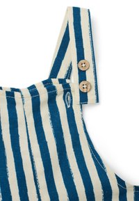 Tessuto di cotone a righe, blu e avorio, con chiusura a bottone in legno sulla tracolla regolabile e dettagli di cucitura.