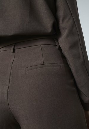 Brune skræddersyede bukser med et glat, struktureret stof, enkelt baglomme og slim fit, suppleret af en matchende overdel.
