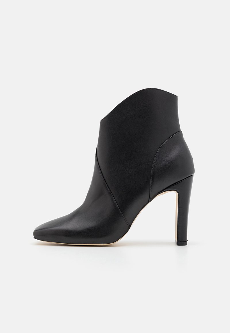 Bottine en cuir noir avec un bout pointu, un talon haut et un design unique plié à l'avant. Texture lisse et détails minimaux.