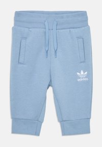 Calções jogger de algodão azul claro com uma cintura elástica e cordões, dois bolsos laterais e um destaque da marca adidas em branco.