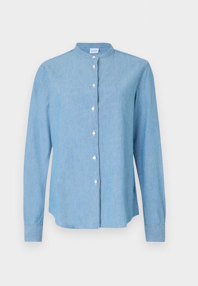 Lyseblå skjorte med knap- ned, lavet af denim. Har en rund krave, lange ærmer og perlemorsknapper foran.