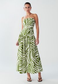 Stropfri maxikjole med grøn- og hvid zebramønster, rynket krop og flydende nederdel. Fremstillet i letvægtsstof.