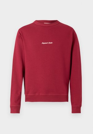 Burgundia puuvillasegusest kangast dressipluus, millel on ümmargune kaelus, soonikust varrukad ja alumine äär. Ees on valge tikandiga tekst "Original Studio".