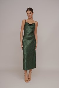 Πράσινο σατέν midi φόρεμα με λαιμόκοψη και λεπτές τιράντες, διακοσμημένο με λουλούδια. Συνδυασμένο με χρυσές σανδάλες με λουράκι στον αστράγαλο. Λείο και κομψό ύφασμα.