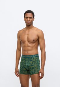 Πράσινα ανδρικά εσώρουχα στυλ μποξέρ με μοτίβο φύλλων σε όλη την επιφάνεια, ελαστική μέση με την επωνυμία "BJÖRN BORG", εφαρμοστή γραμμή και ομαλή υφή υφάσματος.