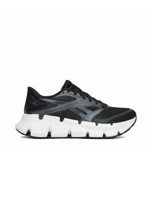 Scarpa da corsa Reebok nera e grigia con suola bianca segmentata e spessa e tomaia in mesh per la traspirabilità.