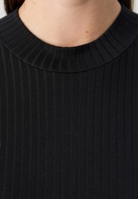 Μαύρη ριγωτή πλεκτή μπλούζα με υφή, στρογγυλή λαιμόκοψη και εφαρμοστή σχεδίαση, κατάλληλη για εκCasual ή για στρώσεις.