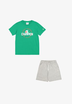 Camiseta de algodón verde con el logo "Champion" en rojo y blanco, combinada con pantalones cortos de algodón gris claro con cinturilla elástica y bolsillos laterales.