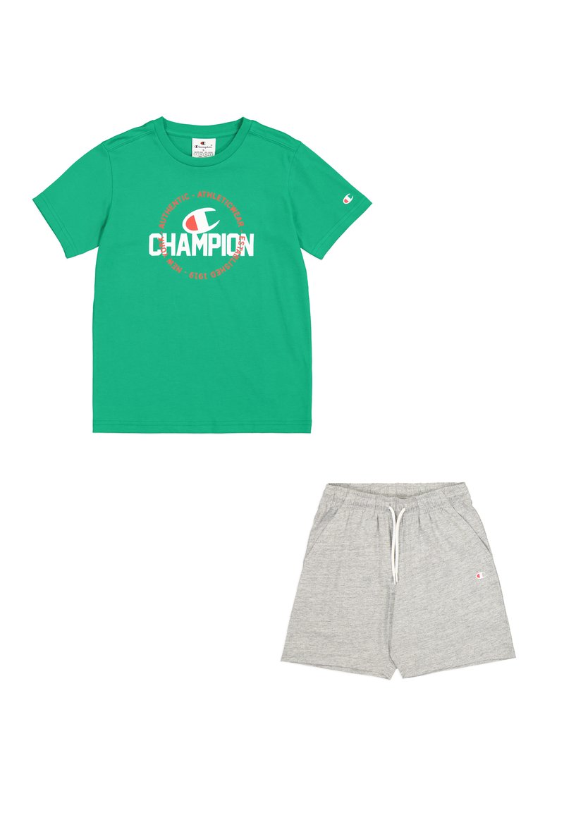 Camiseta de algodón verde con el logo "Champion" en rojo y blanco, combinada con pantalones cortos de algodón gris claro con cinturilla elástica y bolsillos laterales.