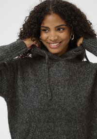 Donkergrijze gebreide hoodie met een trekkoordcapuchon, geribde manchetten en een voorkantzak. Het materiaal lijkt zacht met een gestructureerde afwerking.