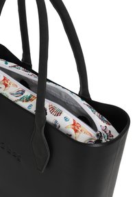Zwarte tote bag met dubbele handvaten; heeft een kleurrijk, patrooninterieur met schelpen en een ritsvak. Glad textuur, gestructureerde vorm.