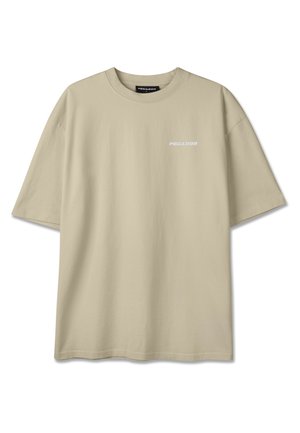 Smėlio spalvos trumpomis rankovėmis marškinėliai su apvalia kaklo iškirpte ir mažu baltu „PEGADOR“ logotipu kairėje krūtinės pusėje.