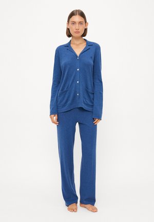 Blå loungewear-settet inkluderer en langermet skjorte med knapper og lommer, samt matchende bukser. Myk tekstur, avslappet passform og ensfarget gjennomgående.