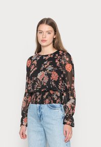 Blusa preta floral com mangas longas, apresentando uma cintura franzida e tecido transparente. Flores em vermelho, laranja e azul contra um fundo escuro.