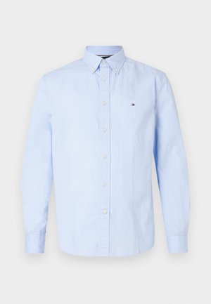 Camicia button-up azzurro chiaro in morbido tessuto di cotone, con colletto a punta, maniche lunghe e un piccolo logo sul lato sinistro del petto.