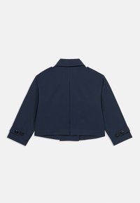 Κοντό ναυτικό μπλε σακάκι με μακριά μανίκια, μανσέτες με κουμπιά και γιακά με άνοιγμα, εμφανιζόμενο από πίσω σε λευκό φόντο.