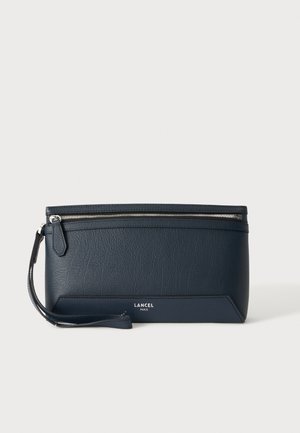 Tummansininen nahkainen rannelaukku hopeisella vetoketjulla ja rannekkeella, Lancel Paris -logo alaosassa etuosassa keskellä.