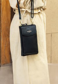 Schwarze Leder-Crossbody-Handytasche mit goldenen Beschlägen, ausgestattet mit einer Klappen- und einer Reißverschluss-Tasche sowie einer strukturierten Oberfläche.