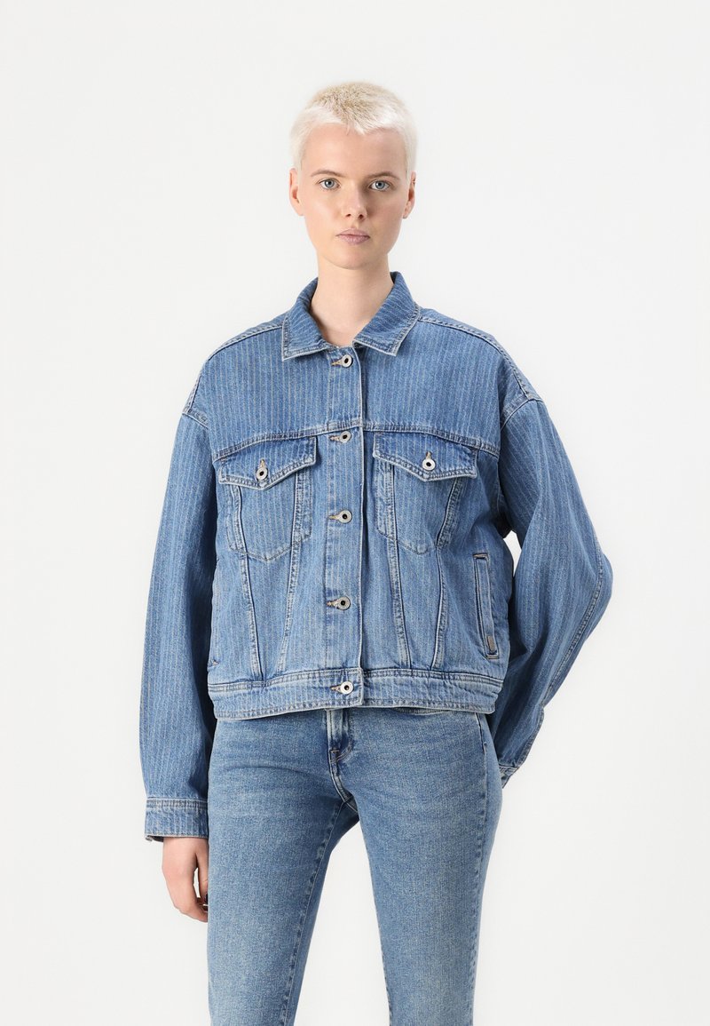 Giacca di jeans azzurro chiaro con vestibilità rilassata, caratterizzata da colletto a contrasto, due tasche sul petto e chiusura a bottoni. Aspetto testurizzato, leggermente sbiadito.
