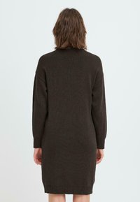 Brun strikket kjole med lange ermer, ribbet tekstur og avslappet passform. Hemmen når midt på låret og har et enkelt, rent design.