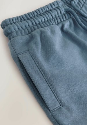 Blauwe katoenen sweatpants met een ribbelband, trekkoord, zijzak en een gladde textuur. De naden zijn zorgvuldig gestikt.