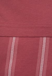 Roter Jerseystoff mit zwei vertikalen weißen Streifenmustern und einer Fischgrattextur, sowie einer flachen Naht am oberen Ende.