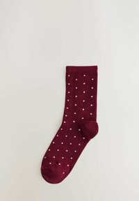 Burgundijas zeķe ar baltām rūtiņām, izgatavota no mīksta auduma, ar pastiprinātu pirkstu daļu un ribotu malām, lai nodrošinātu ciešu fit.