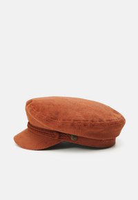 Caciula din corduroy ruginiu, cu coroană plată, soare curbat și bandă împletită. Include un mic accent metalic pe lateral.