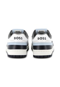 Baskets blanches et grises avec un accent bleu, présentant une tige en cuir lisse, une semelle en caoutchouc et un logo "BOSS" en relief sur le talon.