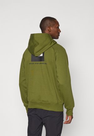 Olijfgroene hoodie met verstelbare capuchon, ribgebreide manchetten en onderrand. Bevat een zwart rechthoekig logo en tekst op de bovenrug. Zachte stoffen textuur.