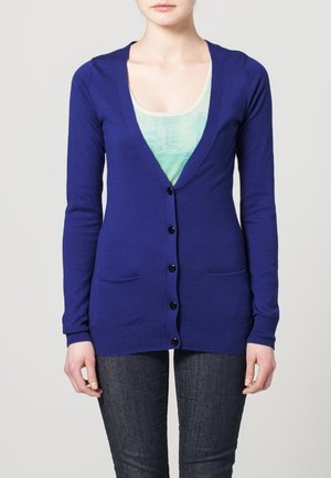 Cardigan blu lavorato a maglia con scollatura a V profonda, cinque bottoni neri e due tasche anteriori. Vestibilità slim con polsini e orlo a costine.