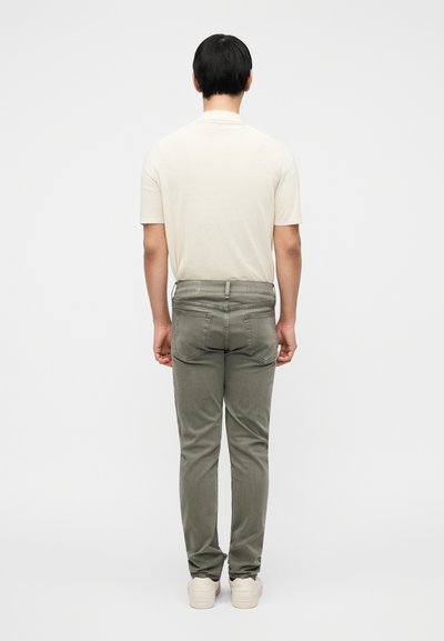 Μπεζ βαμβακερό μπλουζάκι και παντελόνι από λινό σε ελιά πράσινο χρώμα, εφαρμοστή γραμμή, ίσια κοπή, με πίσω τσέπες και απαλή υφή.