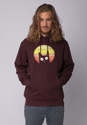 Maroon hoodie featuring a graphic of a cat's face within a yellow to orange circular sunset design. Long sleeves with a front pocket.