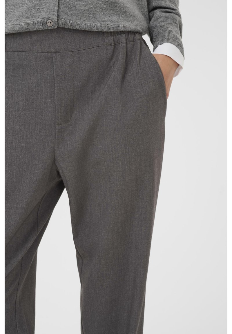 Grijze op maat gemaakte broek met een zachte textuur, voorzien van zijzakken en een losse pasvorm. Elastische tailleband voor comfort en gemakken tijdens het dragen.