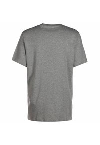 Grå bomulds-t-shirt med korte ærmer og rund hals. Glat tekstur med et ensfarvet design, ingen synlige logoer eller mønstre på ryggen.