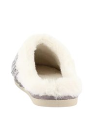 Pantofole grigie e bianche con un interno morbido e peloso e un esterno in tessuto soffice. Design senza schienale con una suola piatta e rigida in gomma.