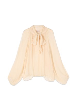 Blusa transparente color crema con mangas largas abullonadas y un lazo atado en el cuello, tela fluida y dobladillo ligeramente desigual.