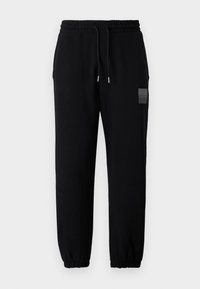 Black jogger pants with an elastic waistband and drawstring, featuring tapered legs and a small logo patch on the thigh.