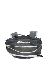 Bolso deportivo gris con detalles blancos, presenta un cierre con cremallera, dos correas ajustables y un bolsillo de malla transparente para una fácil visibilidad.