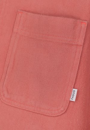 Close-up van een koraalroze stoffen zak met zichtbare stiksels en een klein wit label met de tekst "FAGUO" aan de zijkant.