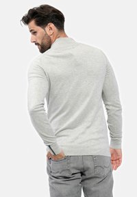 Pullover grigio chiaro a maniche lunghe con colletto, realizzato in morbido tessuto a maglia. Presenta polsini aderenti e un delicato motivo testurizzato.
