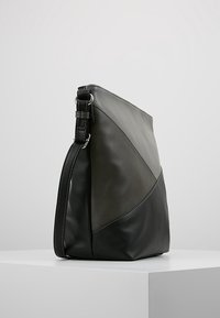 Bolso de hombro de cuero negro y gris con un diseño geométrico, que cuenta con una base plana y una correa ajustable. La textura es suave con detalles sutiles de costura.