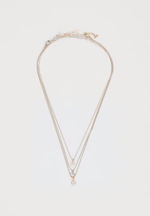 Gold and silver layered necklace featuring three strands with a geometric charm, a round gem, and a teardrop accent. Smooth texture.