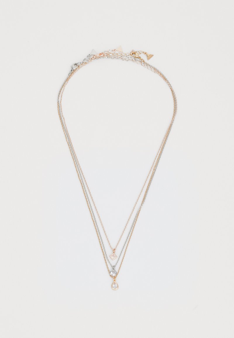 Guld- och silverbelagd halsband med tre trådar, en geometrisk charm, en rund ädelsten och en droppformad detalj. Slät textur.